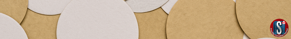 A close-up view of beige and light tan 5-inch PSA no-hole sanding discs layered and overlapping on a smooth surface, showcasing their texture and finish. The Skookum Tools ‘Proudly Canadian Owned’ logo appears in the bottom right corner.