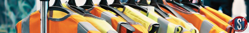 High-visibility safety vests in orange and yellow hanging on a rack, representing Skookum Tools’ reflective clothing and workwear category.